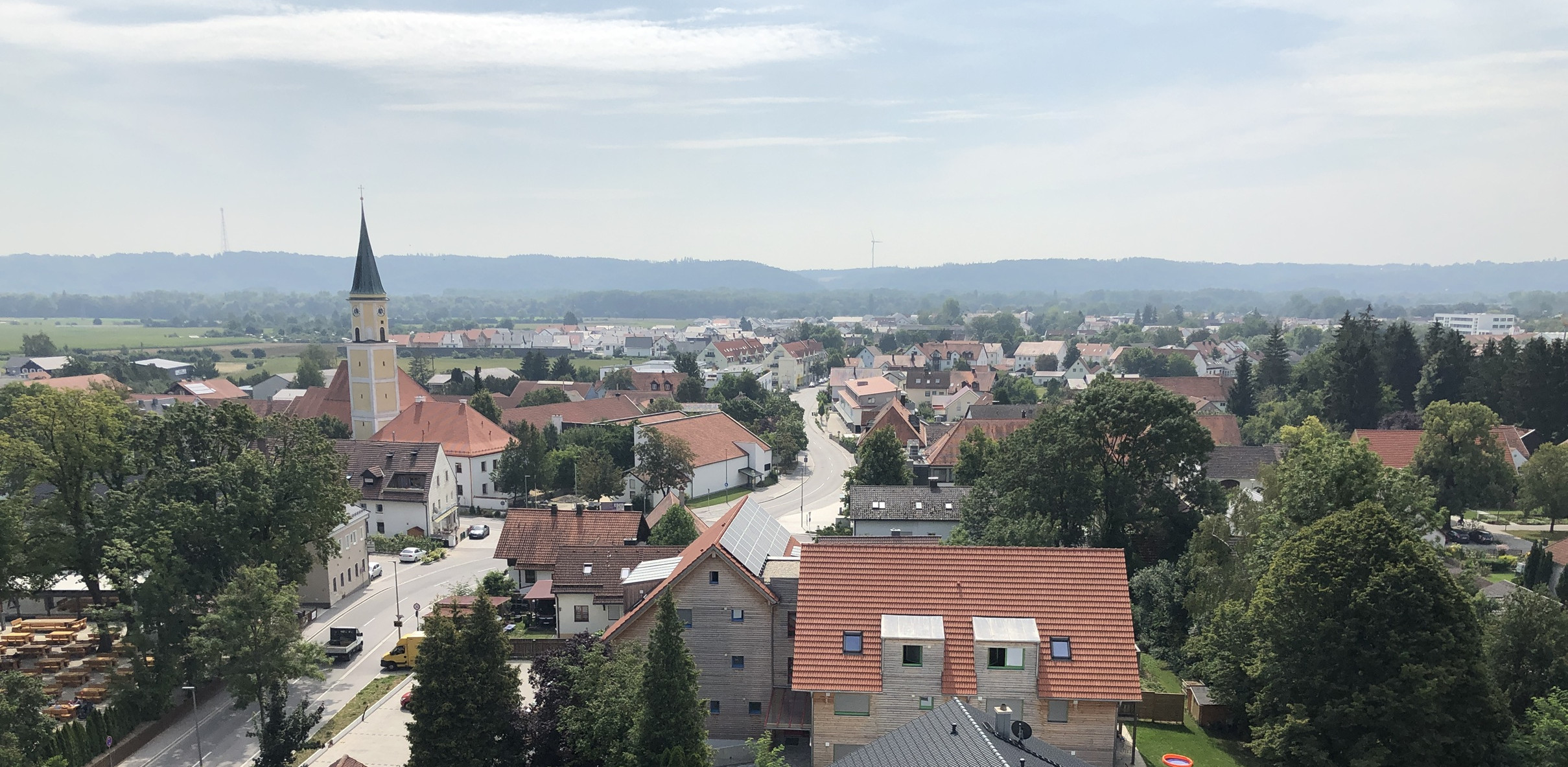 Holzhaus mit Balkon an dem Blumenkästen mit roten Blumen hängen
