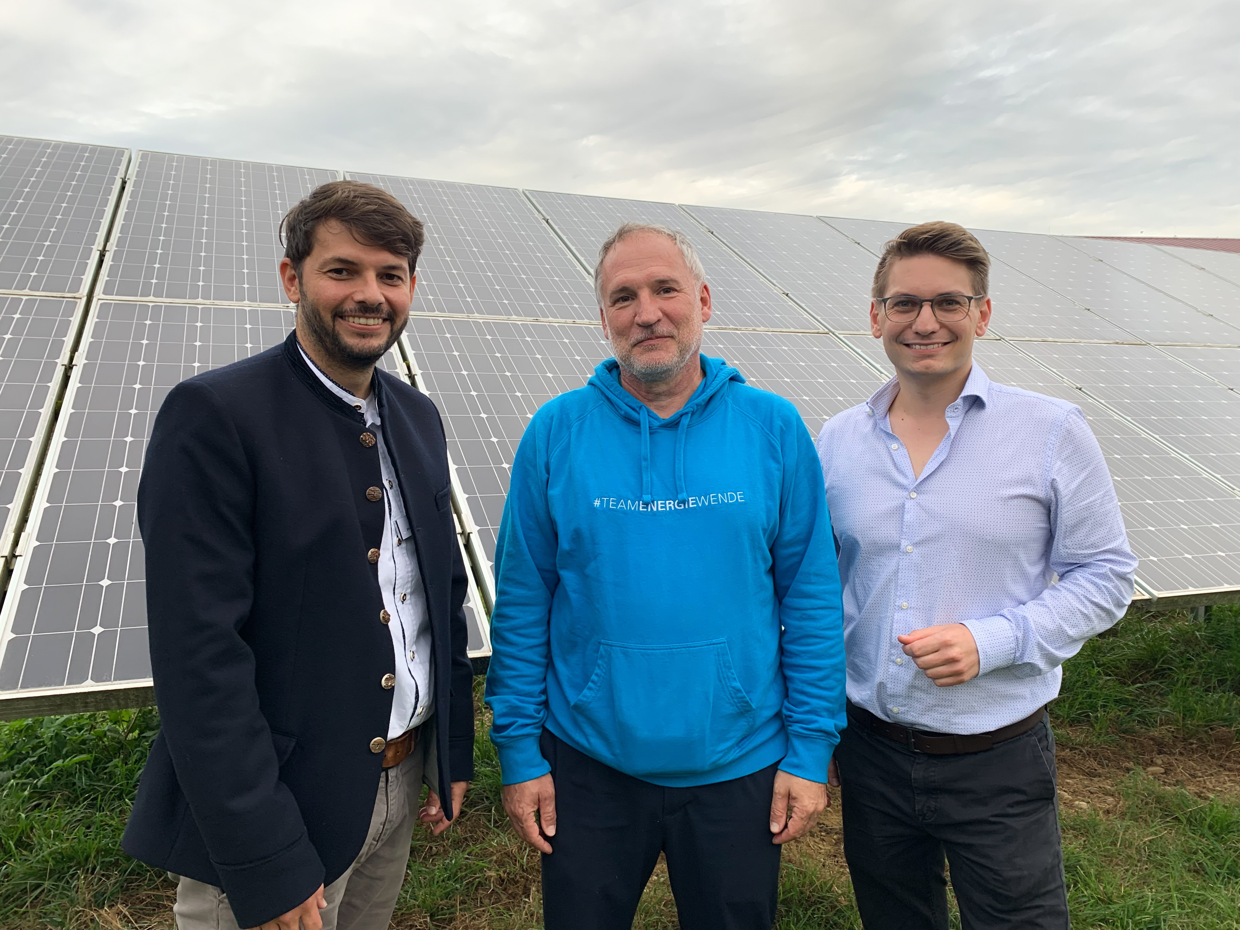 Drei Männer stehen in einem PV-Park